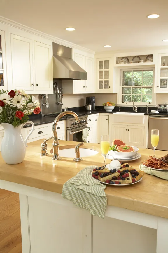 Bright white kitchen with a stainless hood and a bay window over the sink